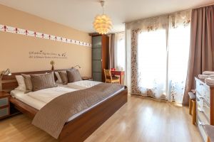 Schlafzimmer mit Doppelbett und Zugang zum großen Balkon - Bild 1: Meersburg - Daisendorf Ferienwohnung mit Seeblick bis 6 Personen